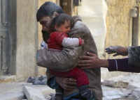 A boy holds his baby sister saved from under rubble, who survived what activists say was an airstrike by forces loyal to Syrian President Bashar al-Assad in Masaken Hanano in Aleppo February 14, 2014